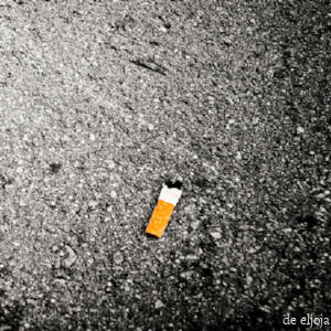 Una colilla de cigarrillo tirada en el piso.
