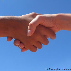 Dos personas de diferentes razas estrechándose las manos.