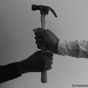 Fotografía de dos manos empuñando un martillo.